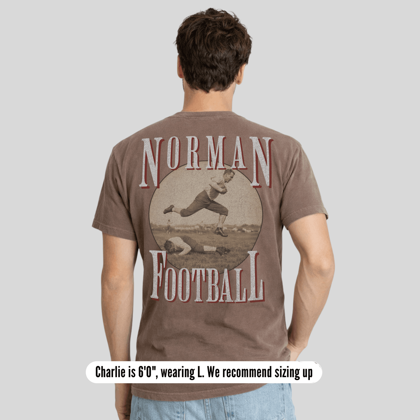Man wearing a brown t-shirt with 'Norman Football' graphic on the back against a gray background