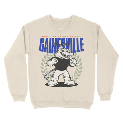 Beige sweatshirt with cartoon alligator and 'Gainesville' text on a white background