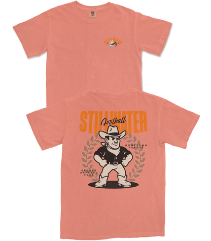 Peach-colored t-shirt with a graphic design of a cowboy and text on a white background