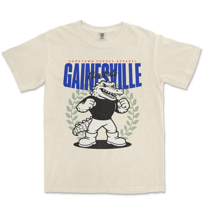 Beige t-shirt with cartoon alligator and 'Gainesville' text on a white background