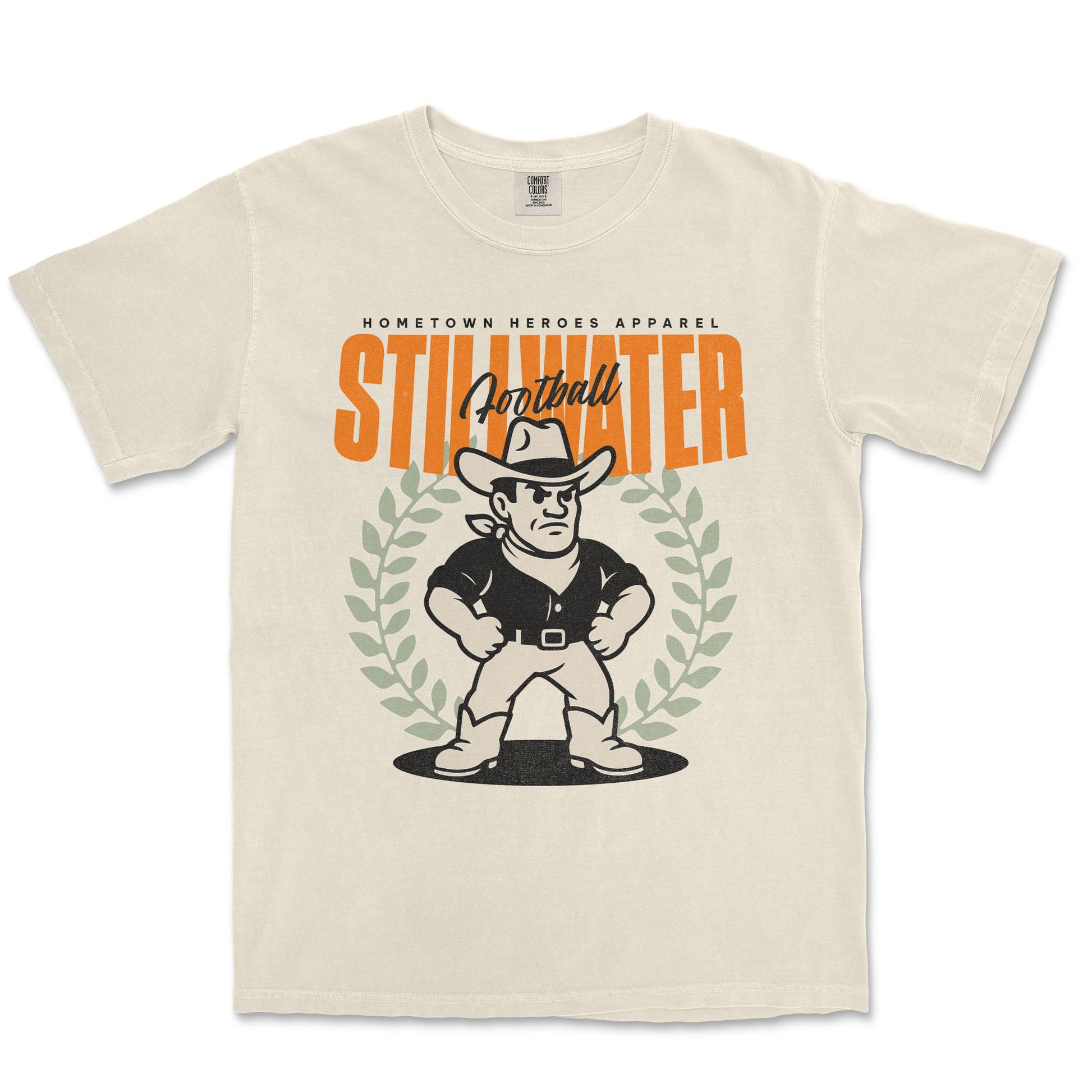 Beige t-shirt with a graphic of a cowboy and text 'Hometown Heroes Apparel Stillwater Football' on a white background