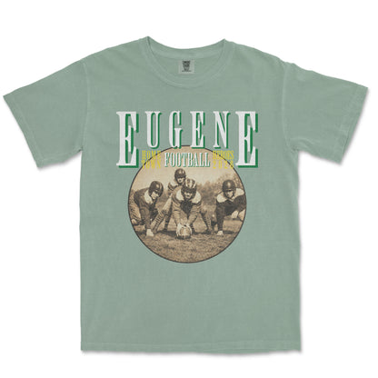 Green t-shirt with vintage football graphic and 'Eugene' text on a white background