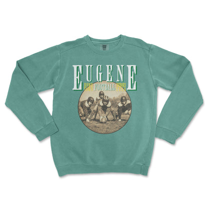 Teal sweatshirt with vintage football graphic and 'Eugene' text on a white background