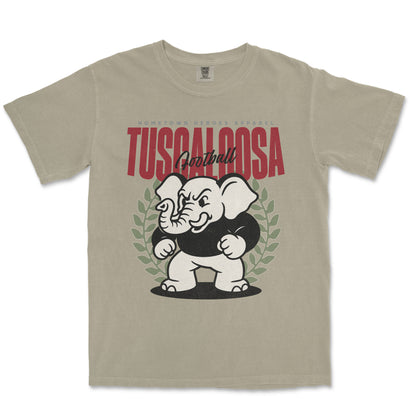 Beige t-shirt with an elephant graphic and 'Tuscaloosa' text on a white background