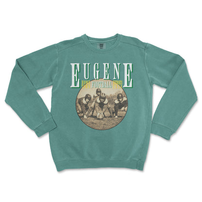 Teal sweatshirt with vintage football graphic and 'Eugene' text on a white background