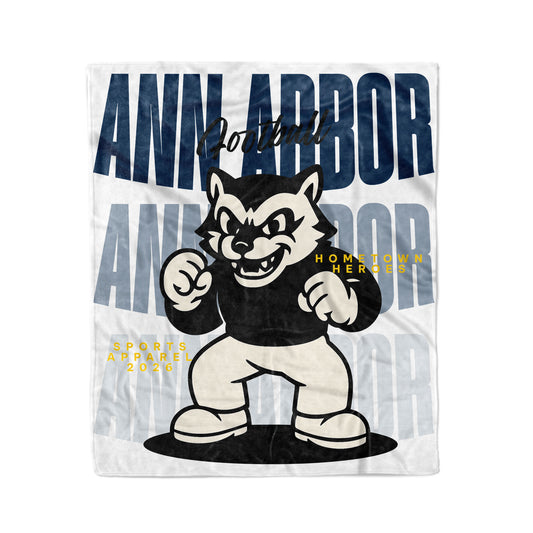 Fleece blanket with a cartoon wolf mascot and 'Ann Arbor' text on a white background
