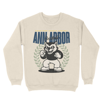 Beige sweatshirt with a graphic of a bear mascot and 'Ann Arbor' text on a white background
