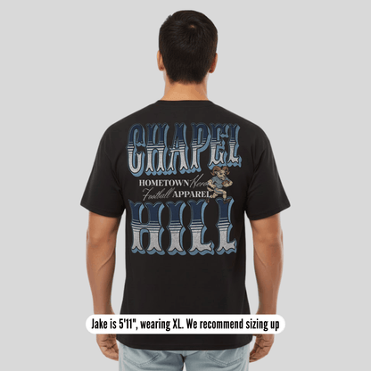 Person wearing a black t-shirt with 'Chapel Hill' text and graphics on the back, on a plain background.