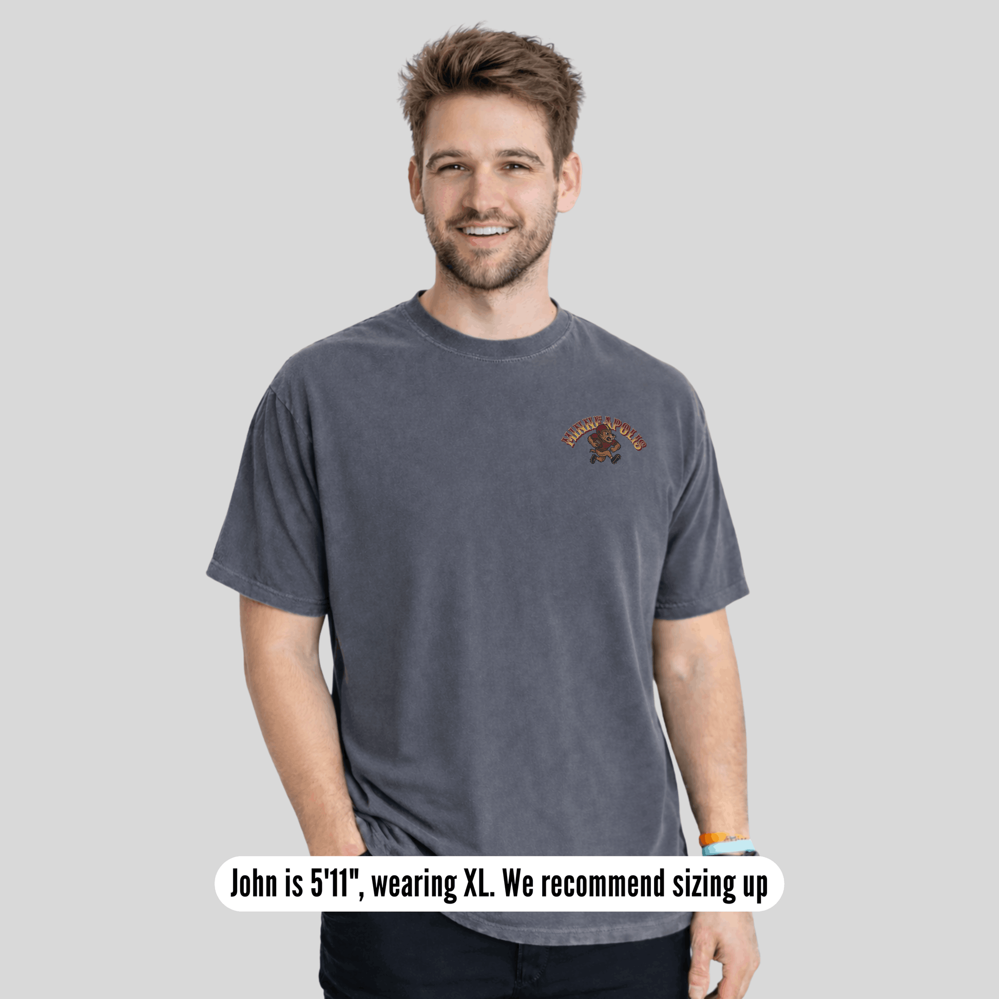 Man wearing a gray t-shirt with a logo on a light gray background