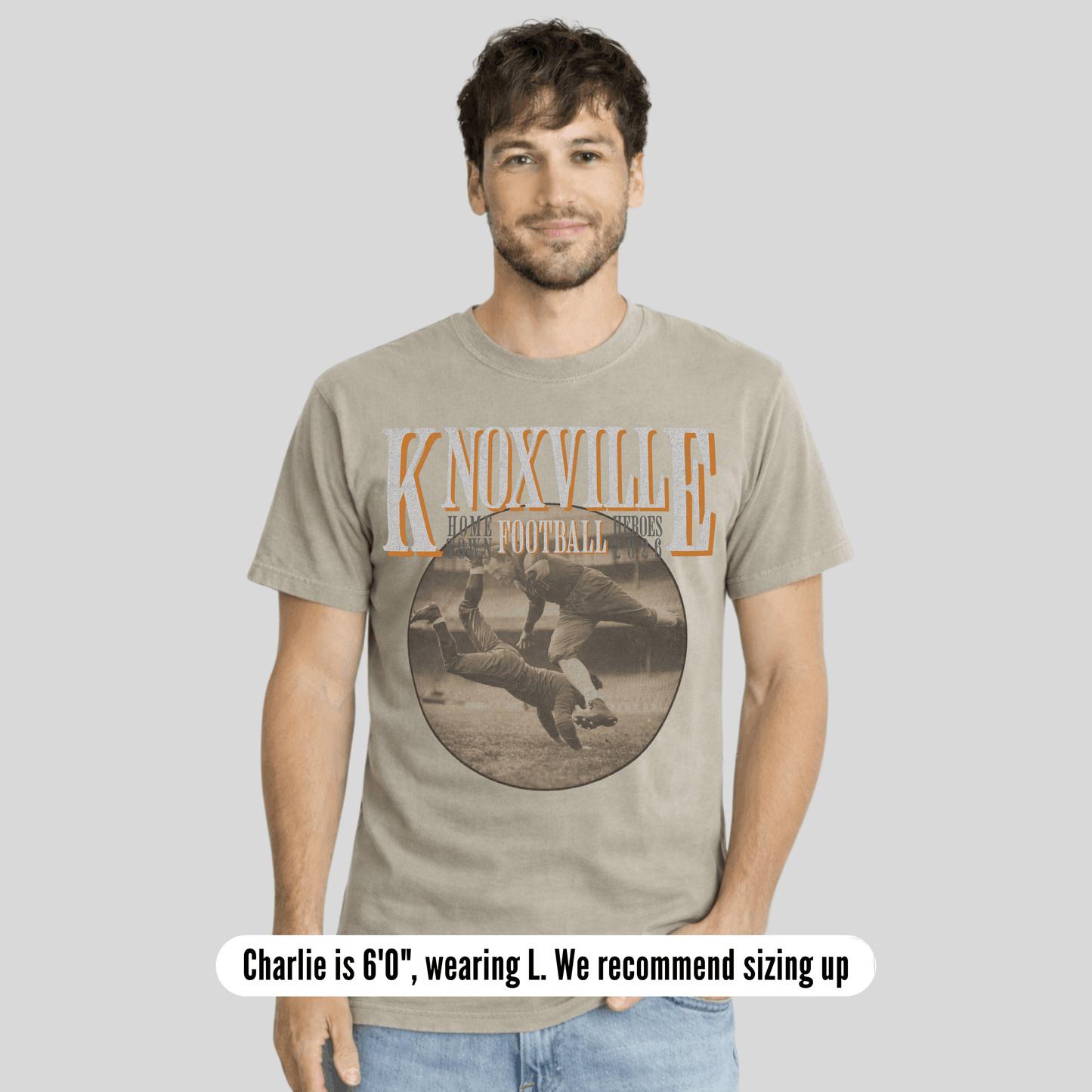 Man wearing a t-shirt with 'Knoxville' graphic design on a plain background