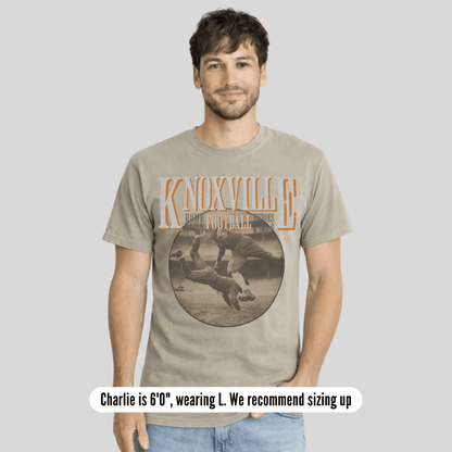 Man wearing a t-shirt with 'Knoxville' graphic design on a plain background