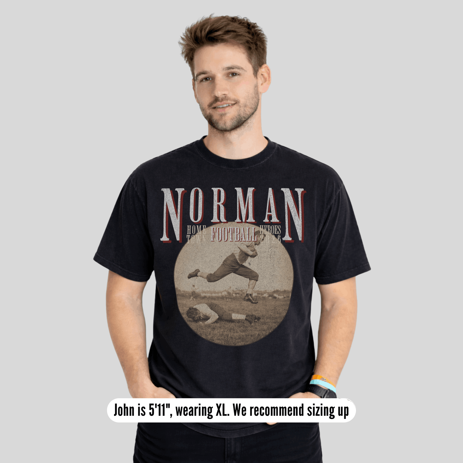 Man wearing a black t-shirt with 'Norman' and a vintage graphic on a gray background