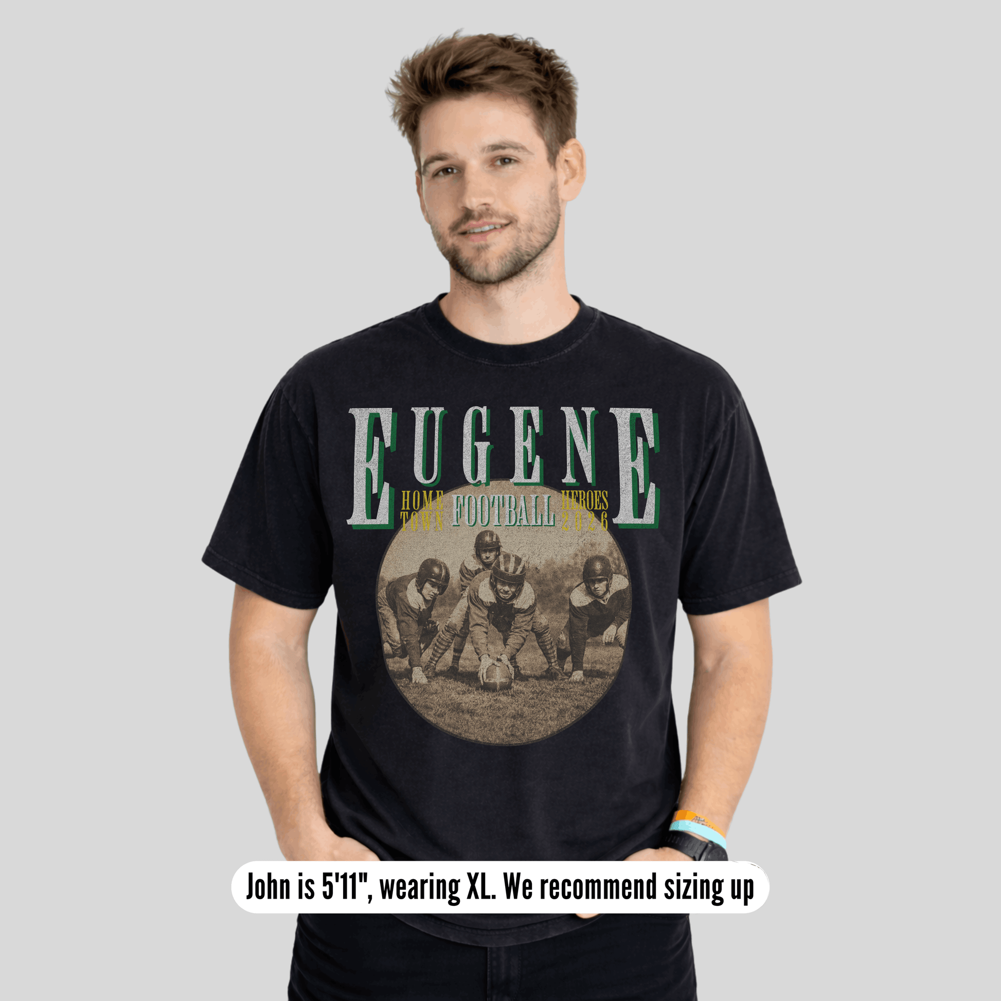 Man wearing a black t-shirt with 'Eugene' and football graphic on a gray background