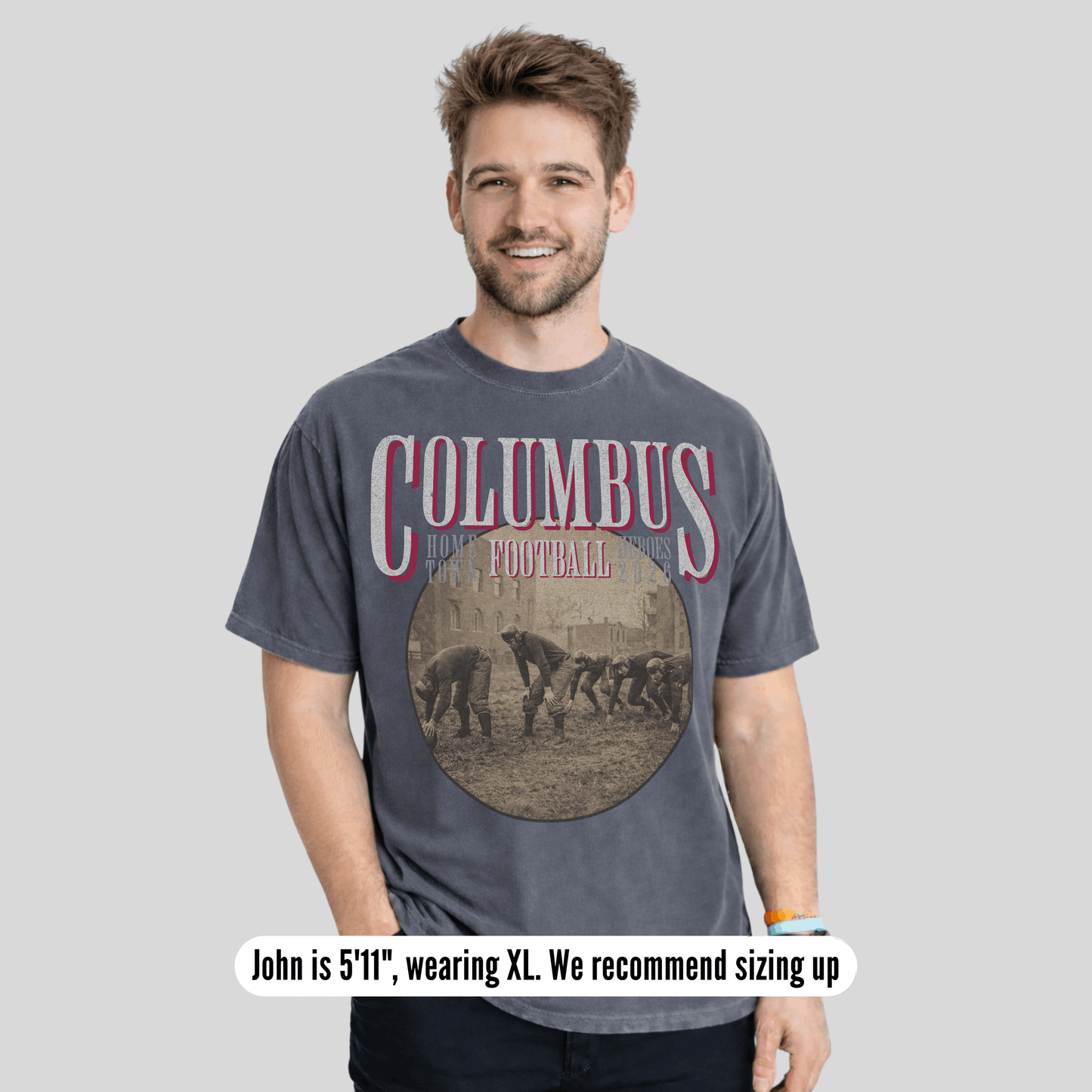 Man wearing a 'Columbus Football' t-shirt on a gray background