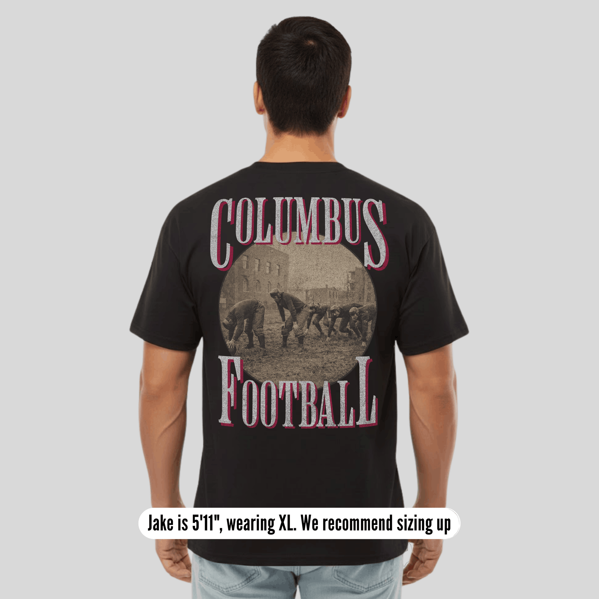 Person wearing a black t-shirt with 'Columbus Football' design on the back, standing against a plain background.