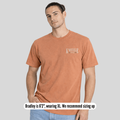 Man wearing a brown t-shirt with 'Knoxville' text on a gray background