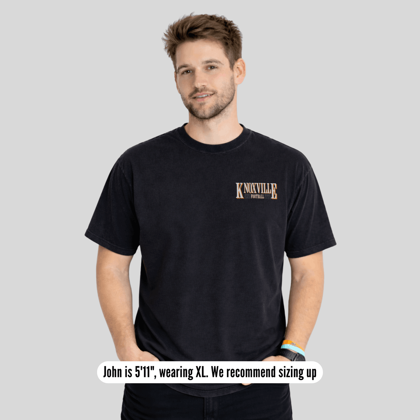 Man wearing a black t-shirt with 'Knoxville' text on a gray background