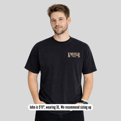 Man wearing a black t-shirt with 'Knoxville' text on a gray background