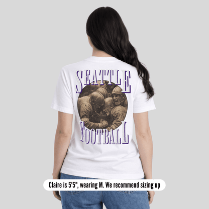 Person wearing a white t-shirt with 'Seattle Football' design on the back, standing against a plain background.
