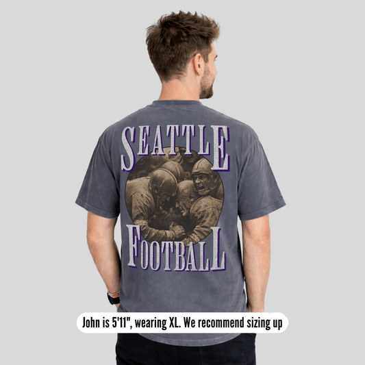 Man wearing a gray t-shirt with 'Seattle Football' design on the back, on a light gray background.