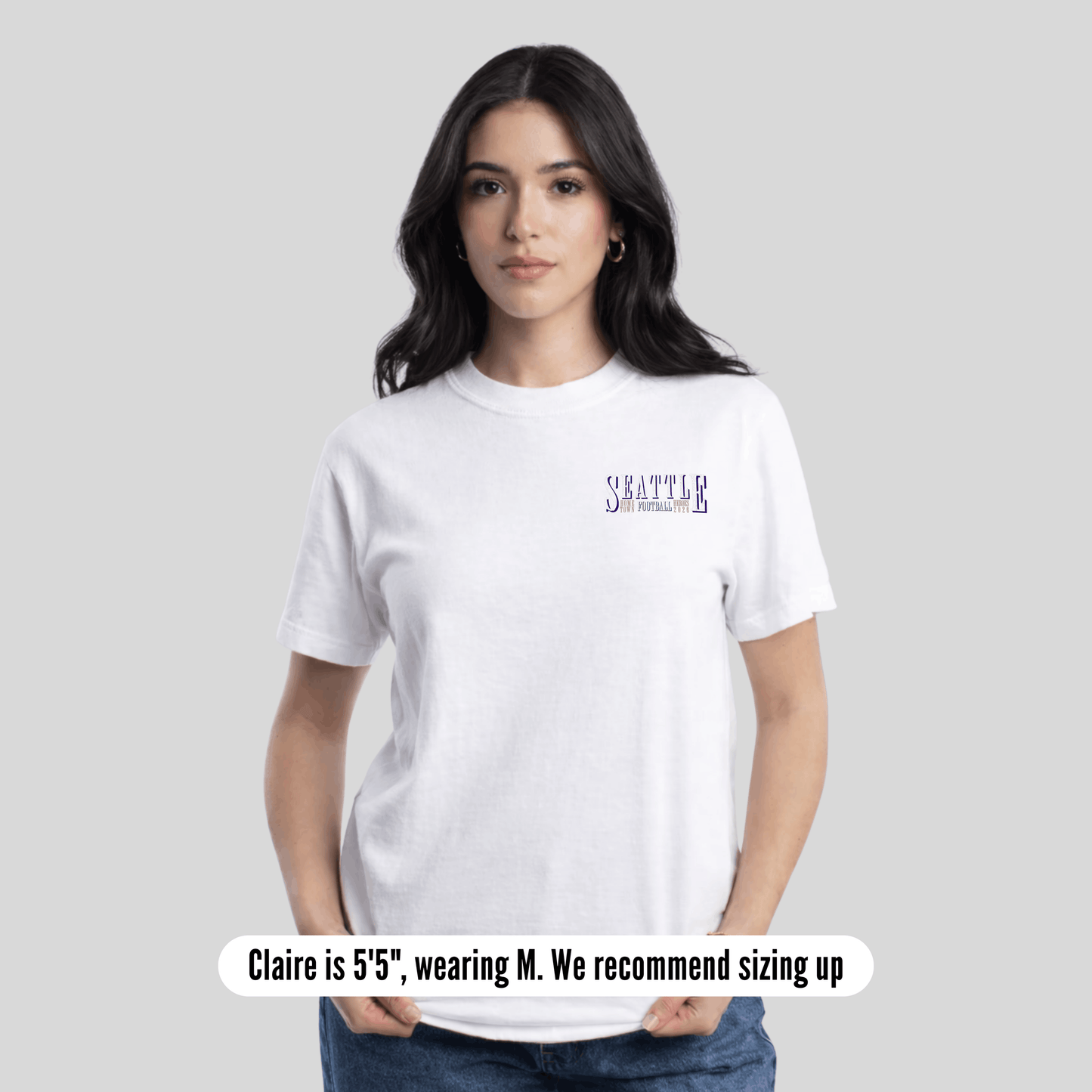 Woman wearing a white t-shirt with text on a plain background