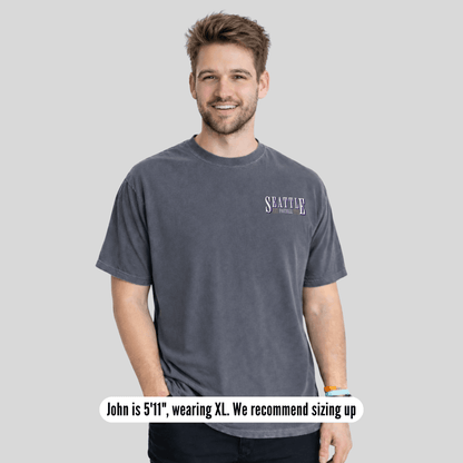 Man wearing a gray t-shirt with 'Seattle' text on a light gray background