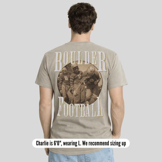 Person wearing a t-shirt with 'Boulder Football' design on the back, standing against a plain background.