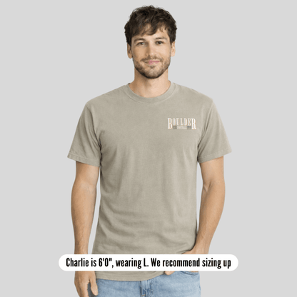 Man wearing a beige t-shirt with text on a gray background
