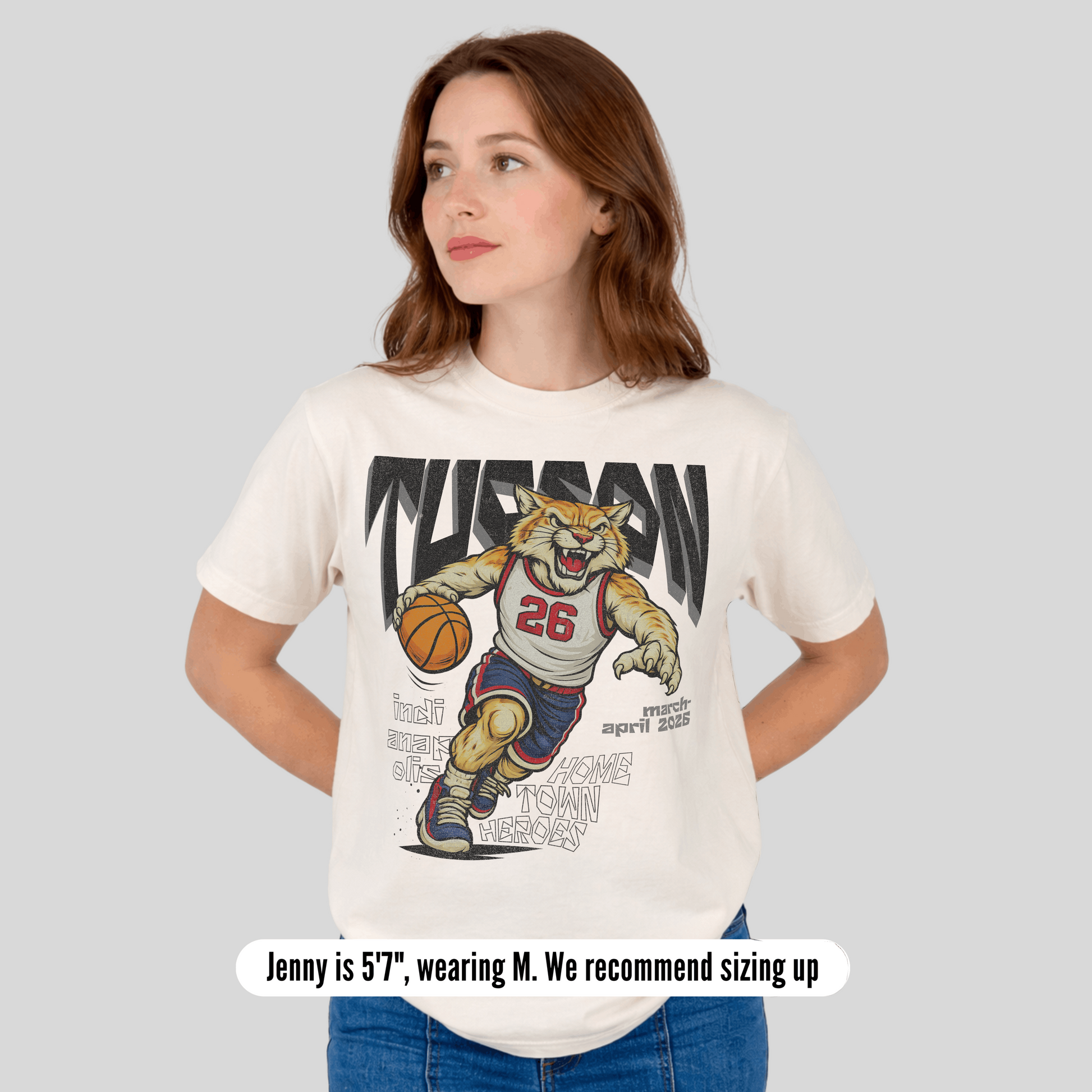 Woman wearing a t-shirt with a graphic of a bear mascot holding a basketball and text.