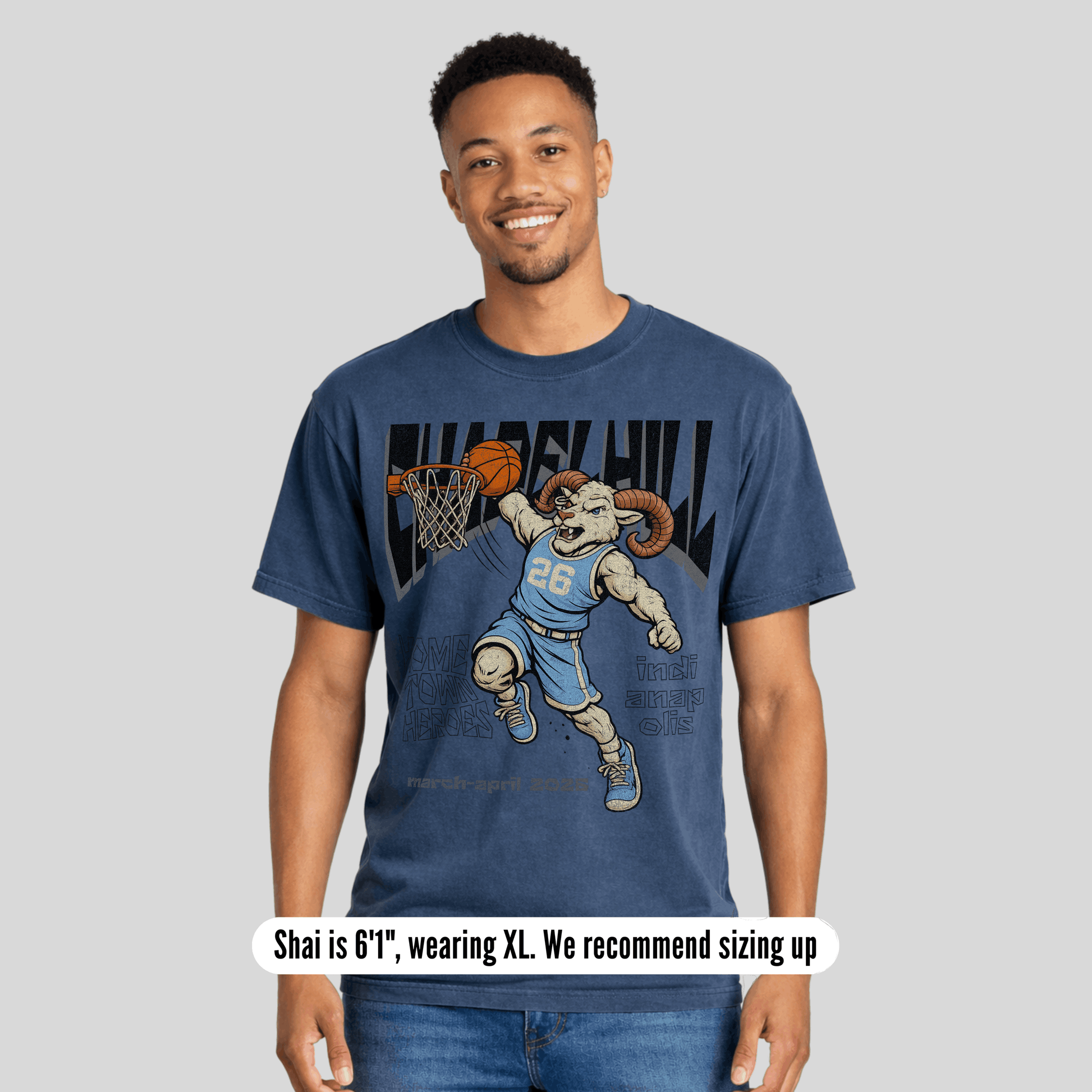Man wearing a blue t-shirt with a graphic design of a ram playing basketball, on a plain background.
