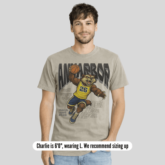 Man wearing a t-shirt with a bear holding a basketball graphic and text.