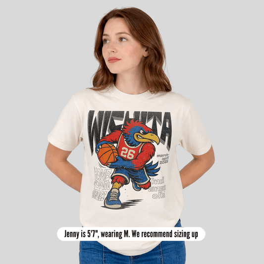 Woman wearing a white t-shirt with a graphic design of a cartoon character holding a basketball on a gray background.