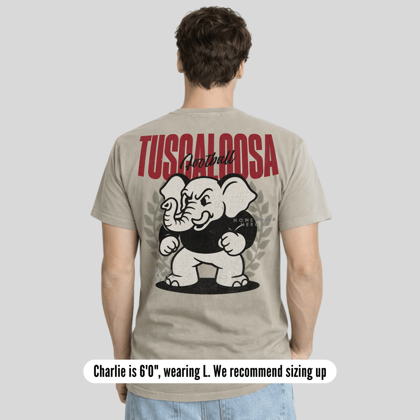 Man wearing a t-shirt with 'Tuscaloosa' and an elephant graphic on the back, on a plain background.