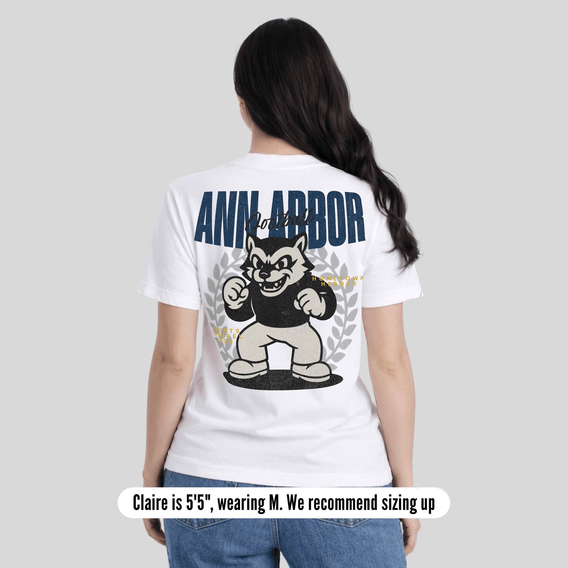 Person wearing a white t-shirt with 'Ann Arbor' and a bear graphic on the back, standing against a plain background.