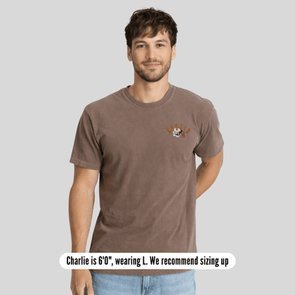 Man wearing a brown t-shirt with a logo on a gray background