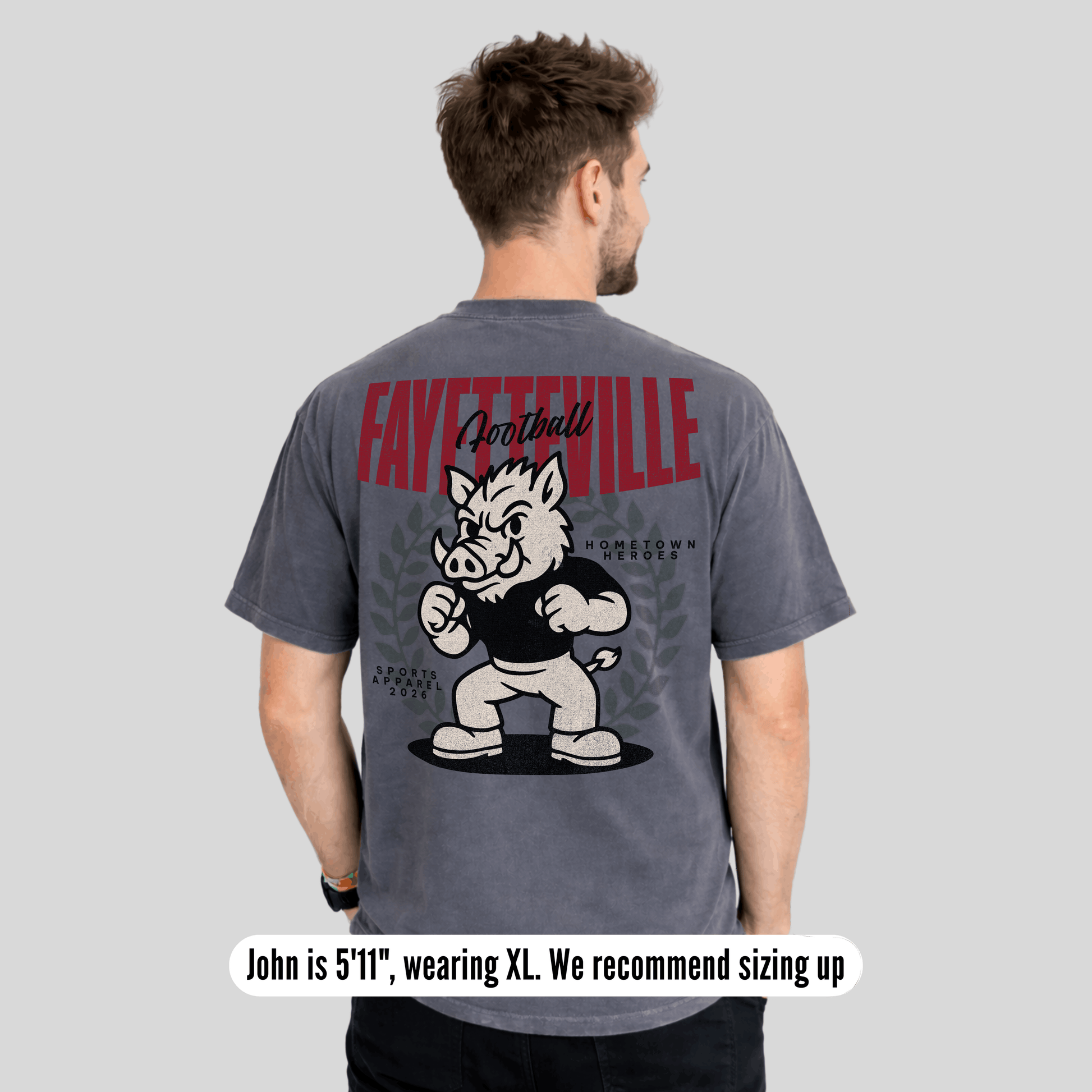 Person wearing a gray t-shirt with 'Fayetteville Football' and a mascot graphic on the back.