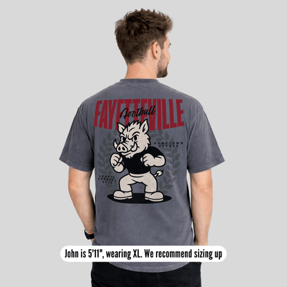 Person wearing a gray t-shirt with 'Fayetteville Football' and a mascot graphic on the back.