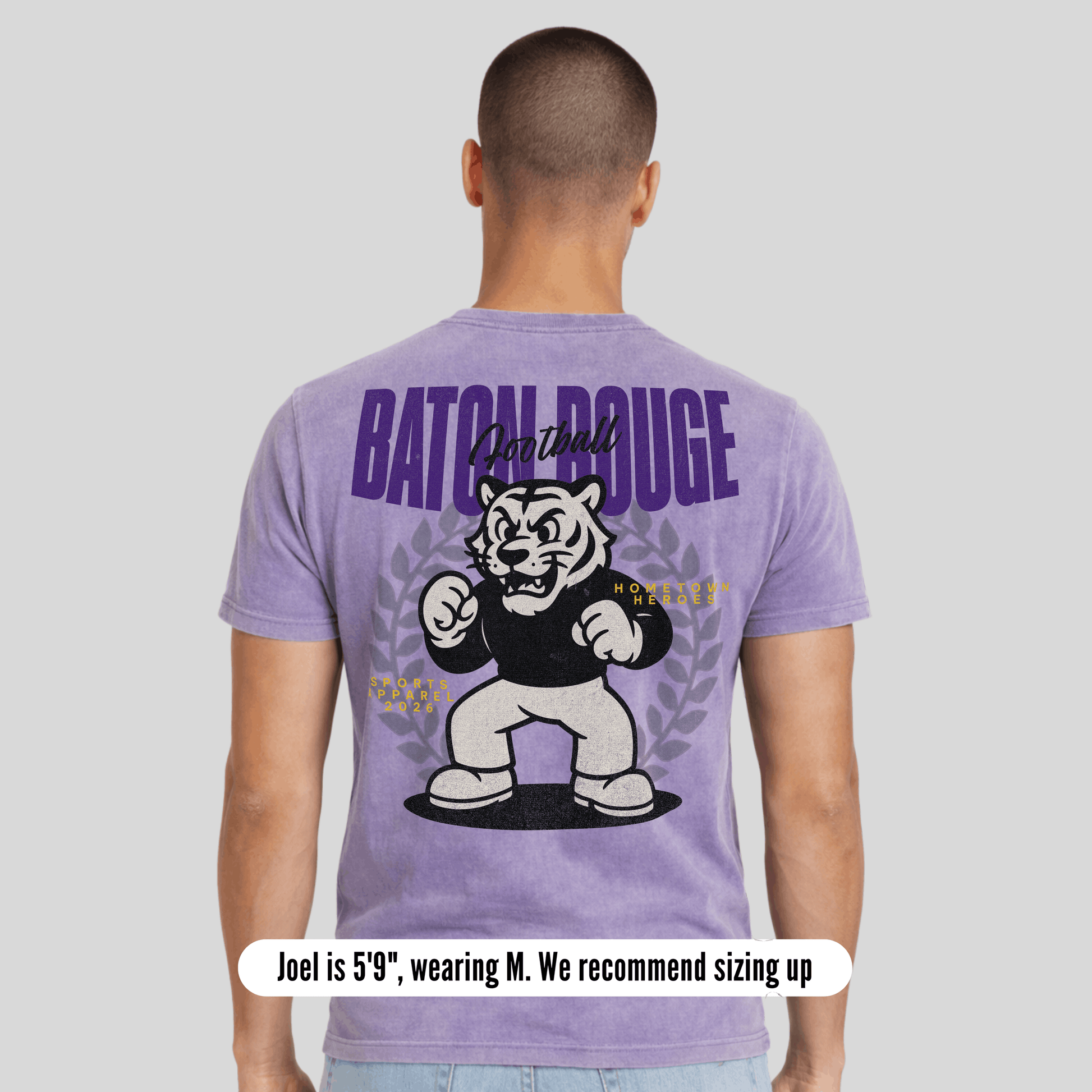 Person wearing a purple t-shirt with a graphic and text on the back, on a light gray background.