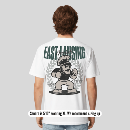 Person wearing a white t-shirt with 'East Lansing' and a Spartan graphic on the back.