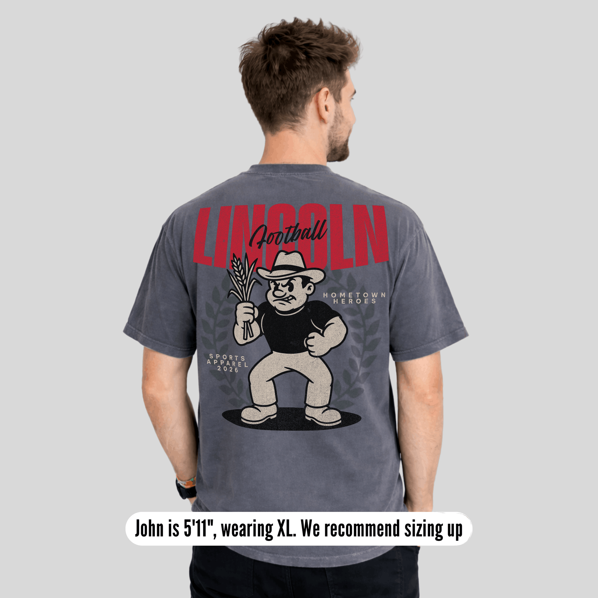 Man wearing a gray t-shirt with a graphic design on the back, featuring text and a cartoon character.
