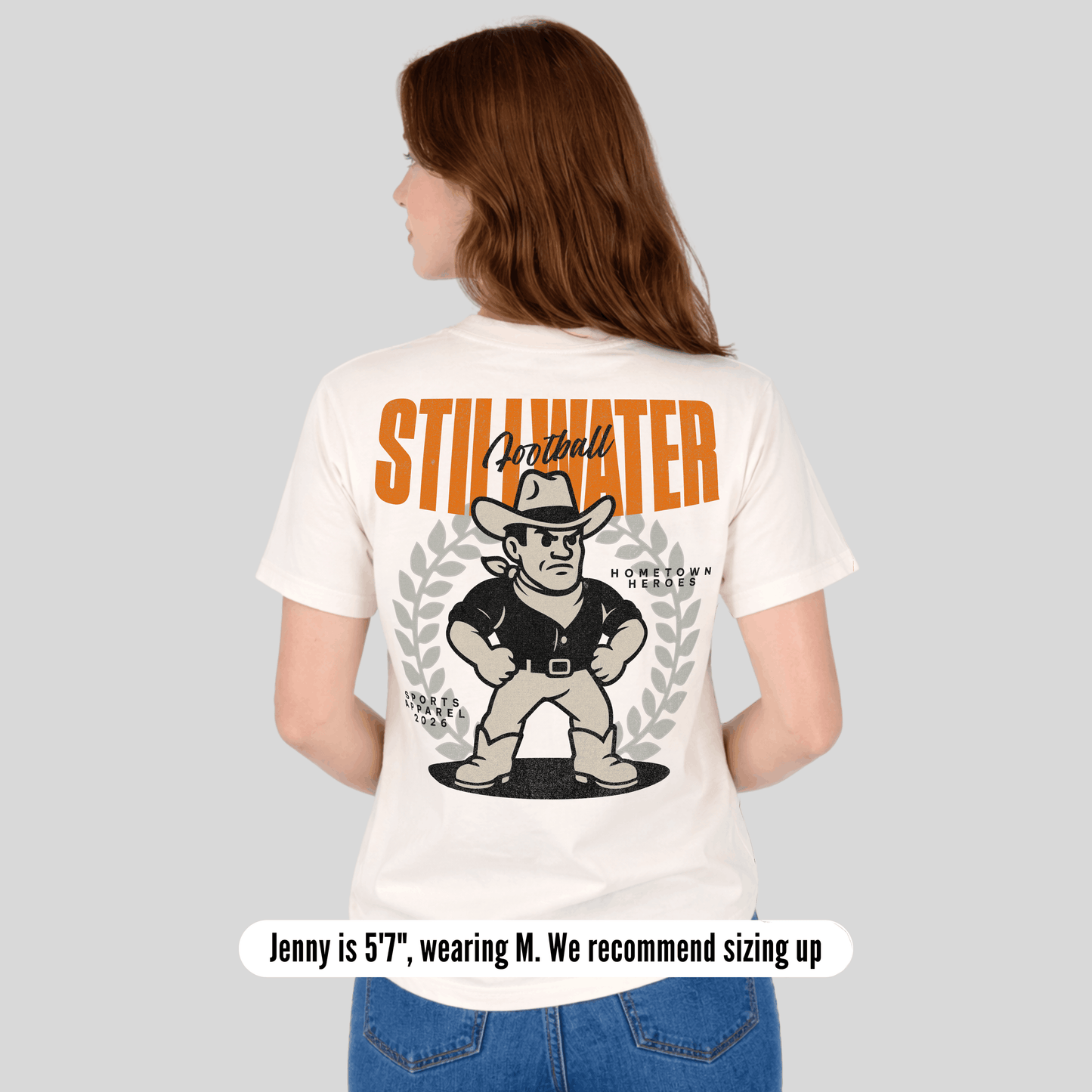 Person wearing a white t-shirt with 'Stillwater' branding and graphic design on the back.