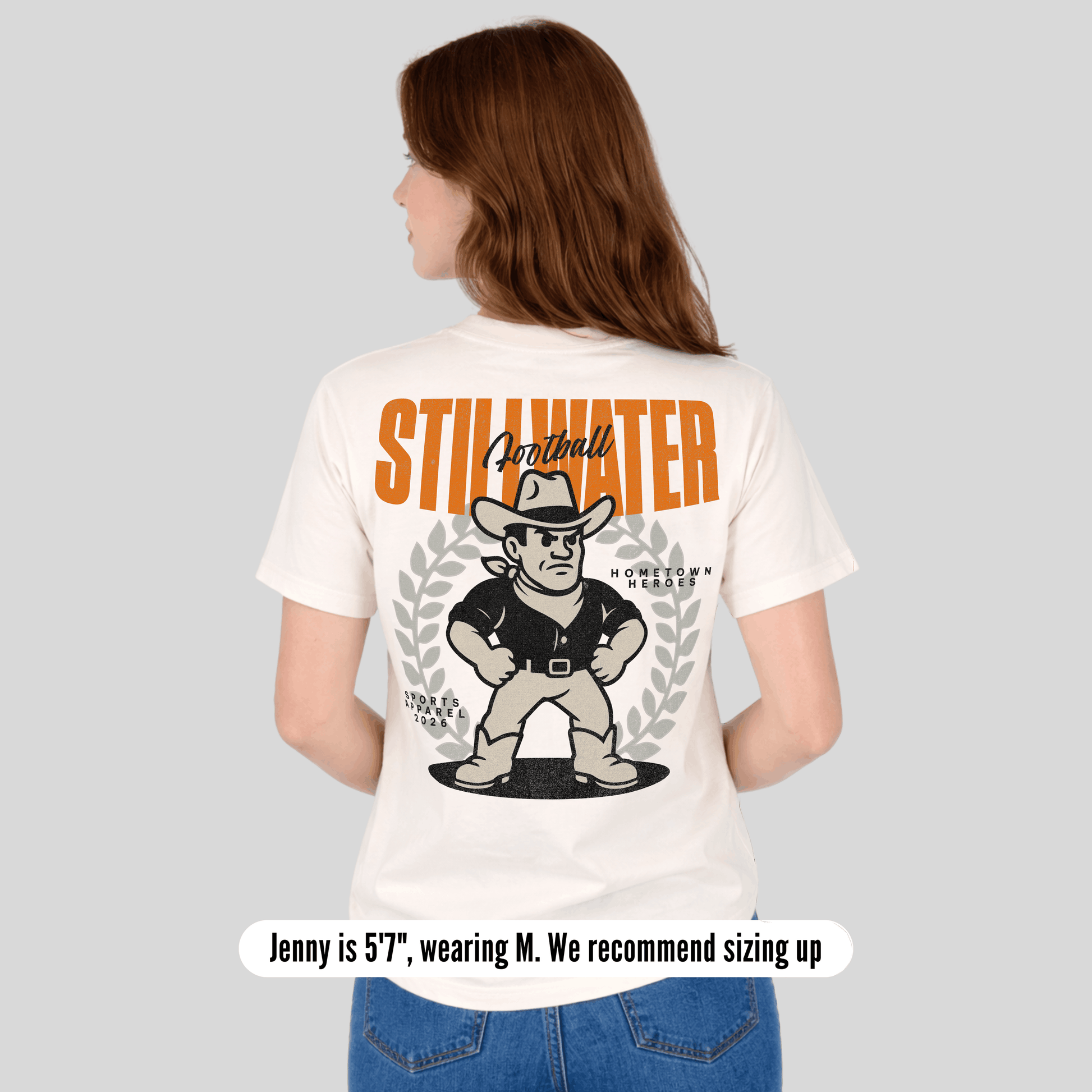 Person wearing a white t-shirt with 'Stillwater' branding and graphic design on the back.