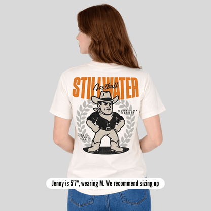 Person wearing a white t-shirt with 'Stillwater' branding and graphic design on the back.