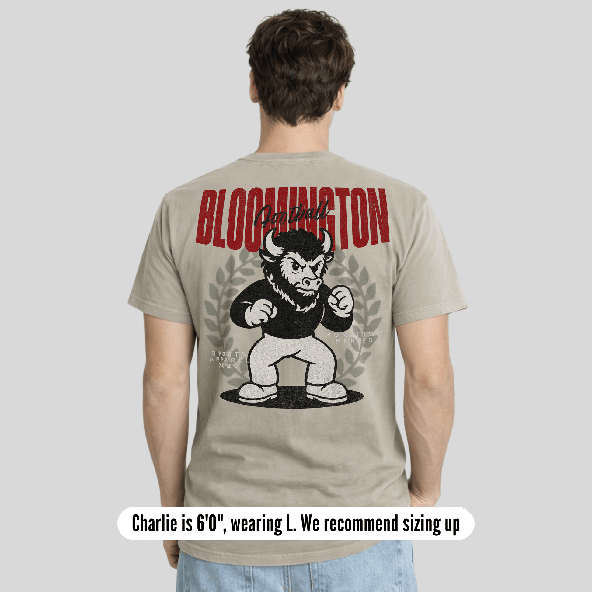 Person wearing a t-shirt with a graphic design and text on the back, on a plain background.