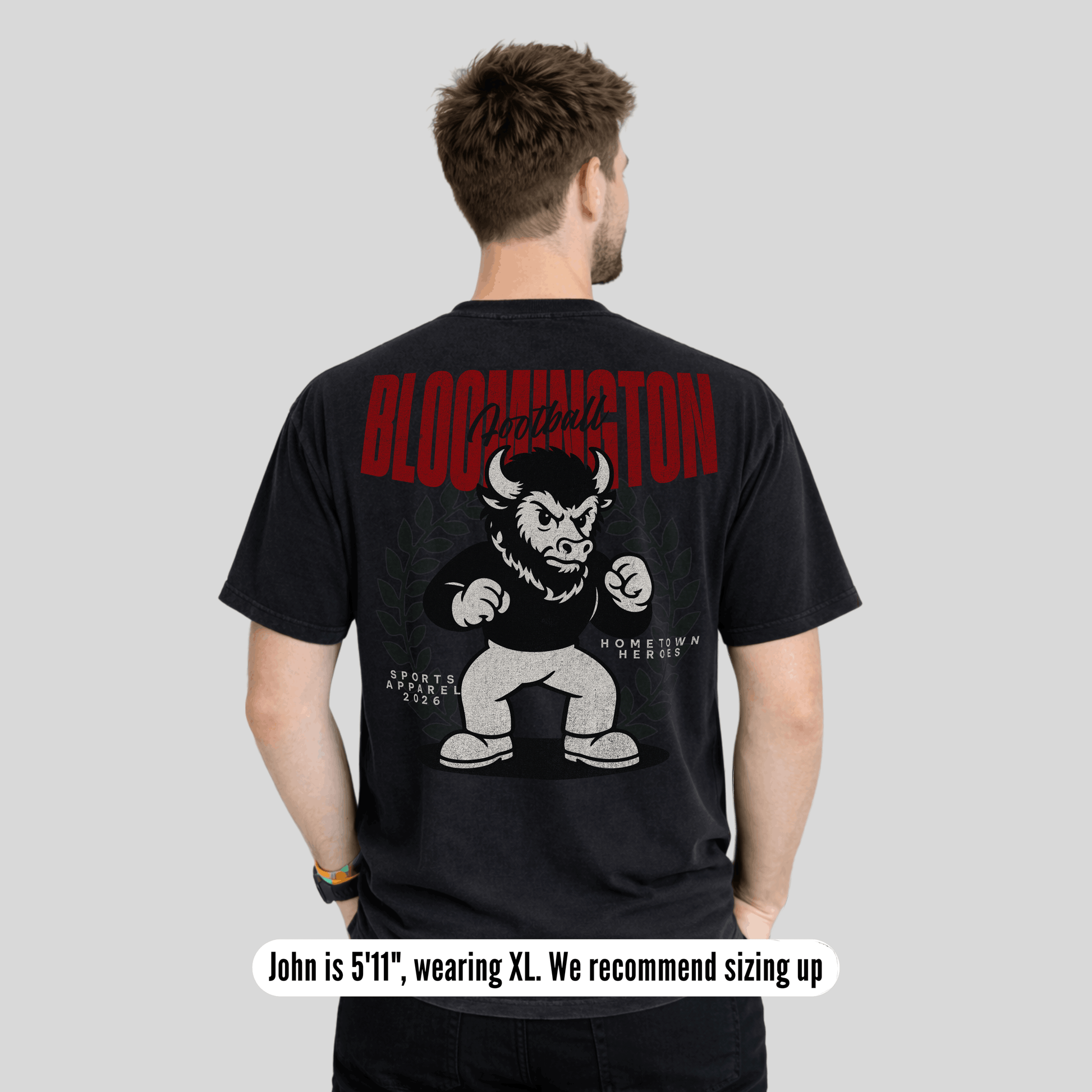 Man wearing a black t-shirt with a graphic design and text on the back, standing against a plain background.