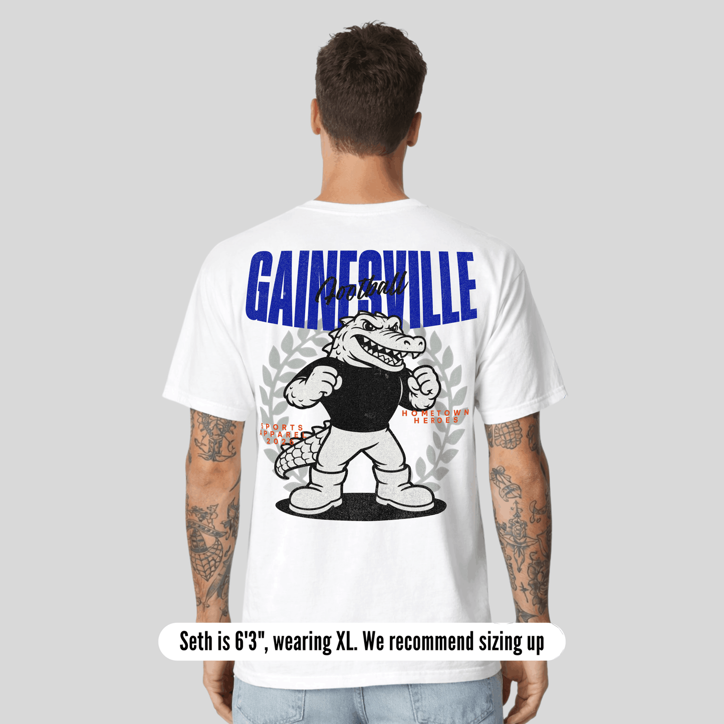 Person wearing a white t-shirt with 'Gainesville' graphic on the back, on a gray background.