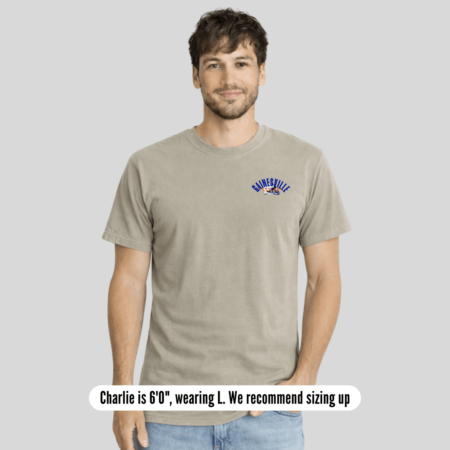 Man wearing a beige t-shirt with a logo on a gray background