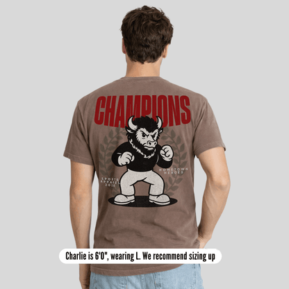 Man wearing a brown t-shirt with a graphic of a bull and 'Champions' text on the back.