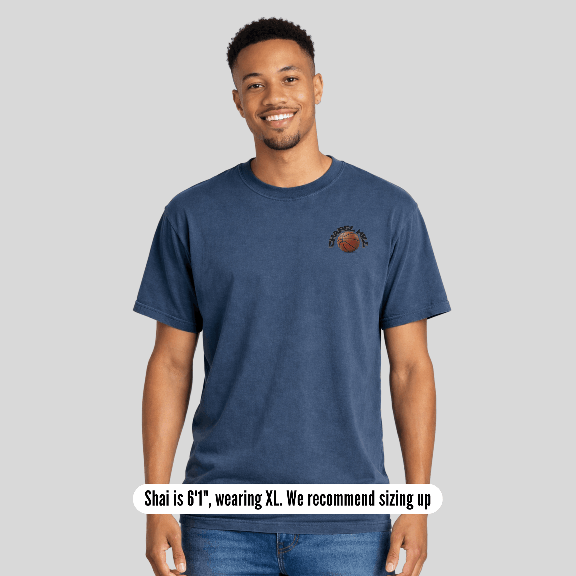 Man wearing a blue t-shirt with a logo on a gray background