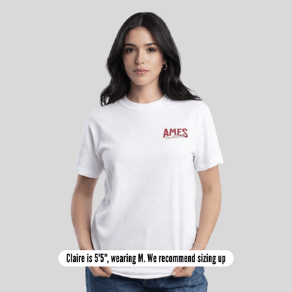 Woman wearing a white t-shirt with 'AMES' logo on a gray background